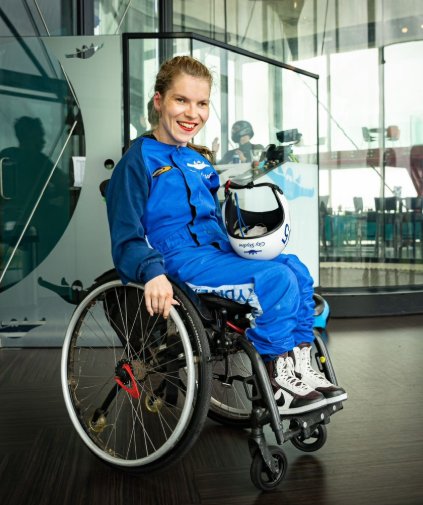 Marleen-paracentrum Marleen in blauw parachutespring pak in een O4 wheelchair
